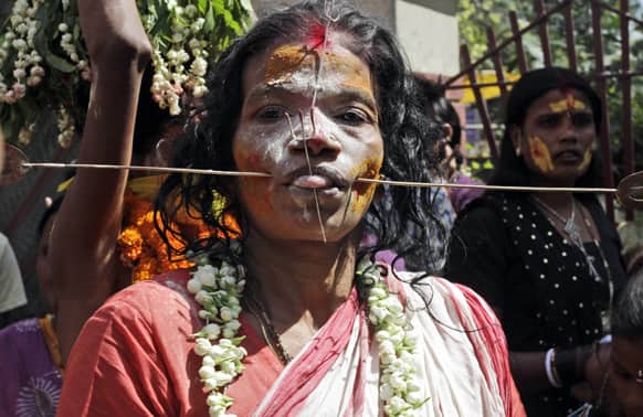 A Hindu woman devotee, cheeks pierced with a metal rod, participates in a religious procession dedicated to Goddess Mutthumariamman in Bandel, about 55 kilometers (34 miles) from Kolkata.