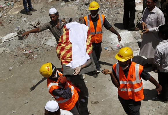 Rescue workers carry a dead body recovered from the debris of a collapsed building on the outskirts of Mumbai.