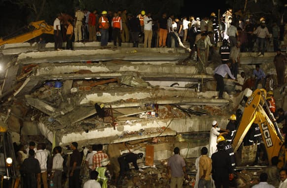 Rescue workers look for trapped people after a residential building collapsed in Thane, Mumbai.