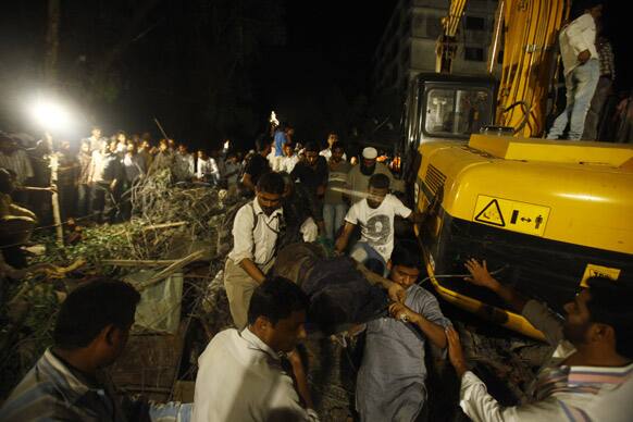 Rescue workers carry the body of a women near the site of a residential building collapsed in Thane, Mumbai.
