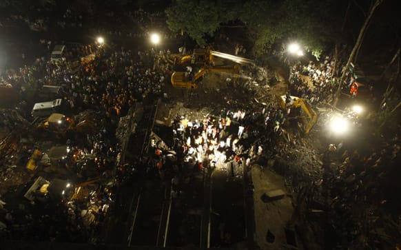 Rescue workers look for trapped people after a residential building collapsed in Thane, Mumbai.