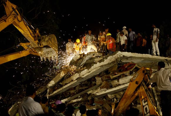 Rescue workers look for trapped people after a residential building collapsed in Thane, Mumbai.