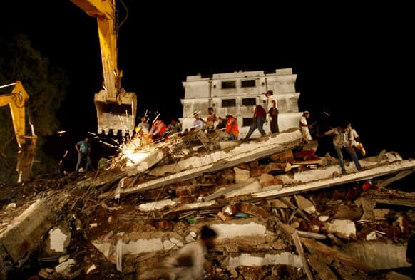 Rescue workers look for trapped people after a residential building collapsed in Thane, Mumbai.
