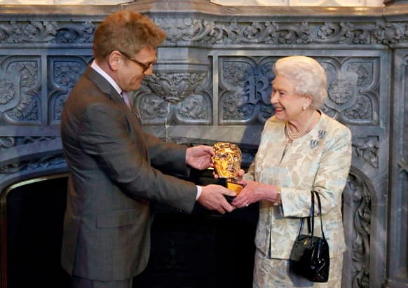 Queen Elizabeth II receives an honorary British Academy award (Bafta), at Windsor Castle, west of London, from actor and director Kenneth Branagh, in recognition of her lifetime`s support of British film and television - and for being the most