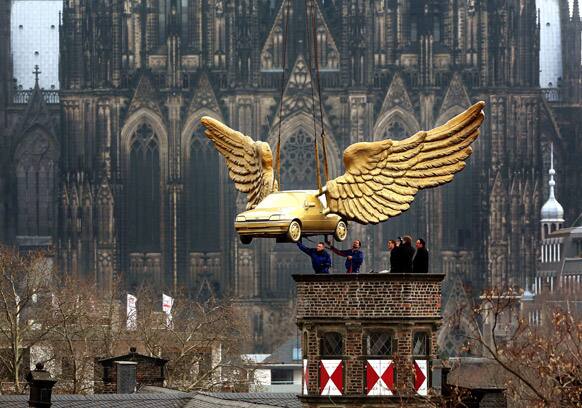 Workers help guide artist HA Schult`s sculpture
