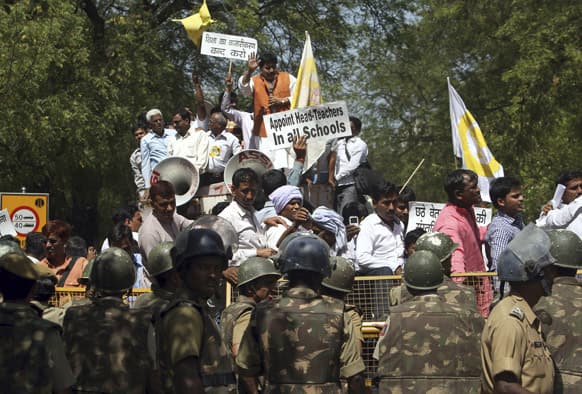 Activists of All India Primary Teacher`s Federation shout slogans from behind a police barricade during a protest in New Delhi. The teachers were protesting against the government’s plan to set up 2,500 secondary schools across the country partnering with private entities.