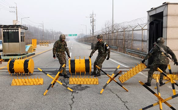 South Korean Army soldiers move barricades to pass vehicles at a military check point in Paju, South Korea, near the border village of Panmunjom.