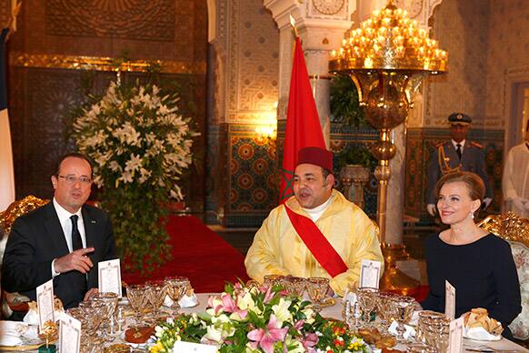 French President Francois Hollande, left, gestures as he poses for photographers with Moroccan King Mohammed VI, center and Hollande`s partner Valerie Trierweiler, right, before the state dinner at the Royal Palace in Casablanca Morocco.