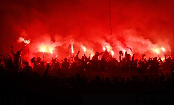 Galatasaray fans hold burning torches during the Champions League quarterfinal first leg soccer match between Real Madrid and Galatasaray at the Santiago Bernabeu stadium in Madrid.