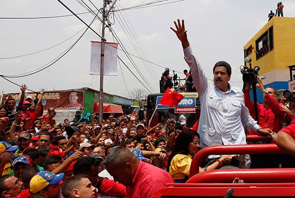 Venezuela`s interim President Nicolas Maduro waves to supporters from the top of a vehicle as he campaigns in a caravan from Sabaneta to Barinas, in Sabaneta, Venezuela.