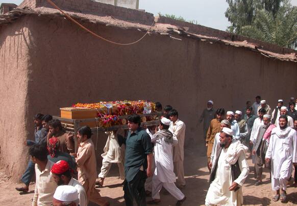 Pakistani villagers carry the body of a community police officer killed in an attack, for burial in suburbs of Peshawar, Pakistan.