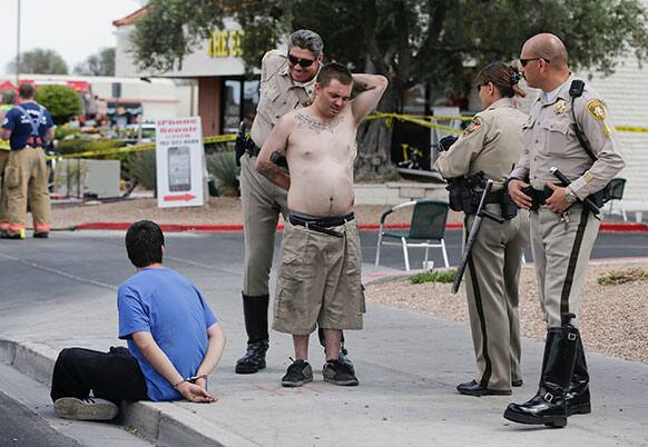 Las Vegas Metro Police officers handcuff a man who was identified by witnesses as the driver of a vehicle that crashed into a crowded restaurant, in Las Vegas.