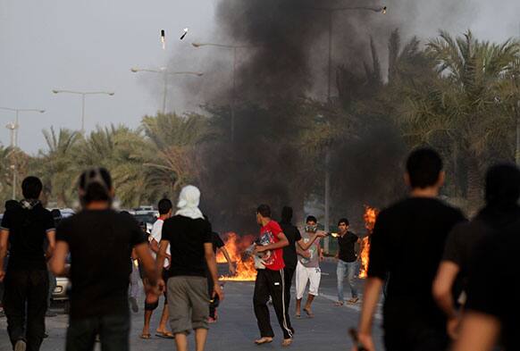 Bahraini anti-government protesters throw petrol bombs toward riot police during clashes in Diraz, Bahrain.