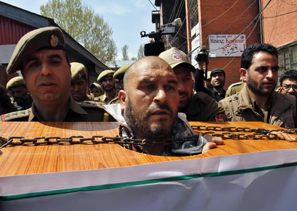 Kashmiri human rights activist Mohammad Ahsan Antoo, enacts as a mock chained prisoner during a protest in Srinagar.
