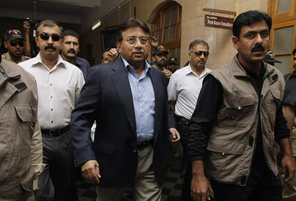 Former Pakistani President Pervez Musharraf, center, surrounded by guards arrives in a court in Karachi, Pakistan.