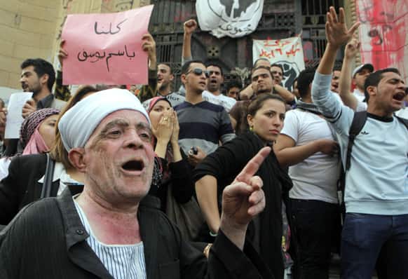 Egyptian activists shout anti-Muslim brotherhood slogans in front of Egypt`s state prosecutors office in support of popular Egyptian television satirist Bassem Youssef, in Cairo.