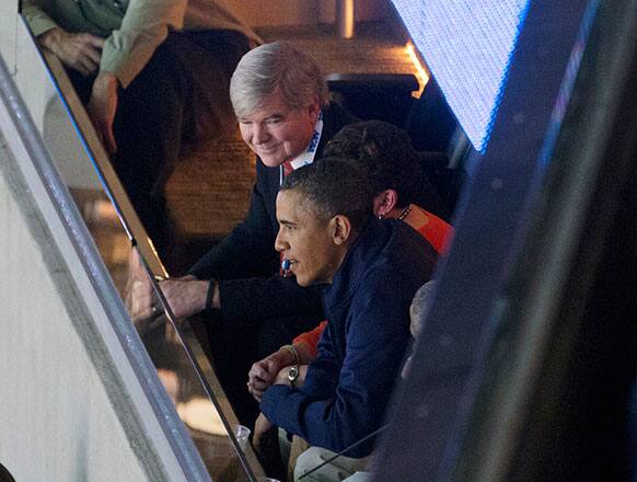President Barack Obama sits with NCAA President Mark Emmert, top, as they attend the East Regional final of the NCAA men`s college basketball tournament between Syracuse and Marquette, in Washington.