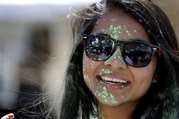Mili Patel, 29, a tourist for the UK, smiles after color dust was thrown at her during a Holi Hai celebration, in Jersey City, N.J.