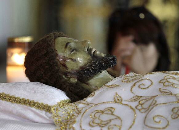 A Filipino devotee prays in front of an image of the dead Jesus as they observe Black Saturday at a church in Manila.