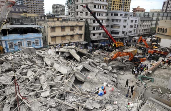 Rescuers using mechanical diggers remove rubble from the site of a collapsed building in downtown Dar es Salaam, Tanzania.