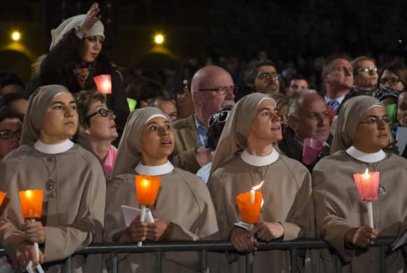 Nuns look at Pope Francis, not pictured, arriving to preside the Via Crucis (Way of the Cross) torchlight procession presided by Pope Francis in front of the Colosseum on Good Friday in Rome.