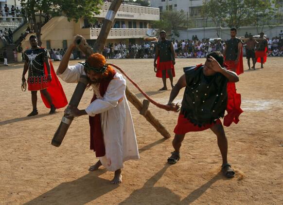 An Indian Christian dressed as Jesus Christ carries a cross while reenacting Jesus’ path to be crucified during Good Friday procession in Hyderabad.