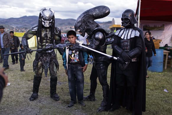 A boy poses for a picture with people wearing costumes of famous sci-fi movies during the Canaan fair which is part of the Holy Week celebrations in Ayacucho, Peru.