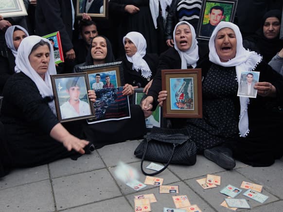 A woman throws her ID card as family members of 34 Turkish Kurdish civilians who were killed in Dec. 2011 in a botched raid in Uludere at Turkey-Iraq border by Turkish military jets that mistook the group for Kurdish rebels based in Iraq.