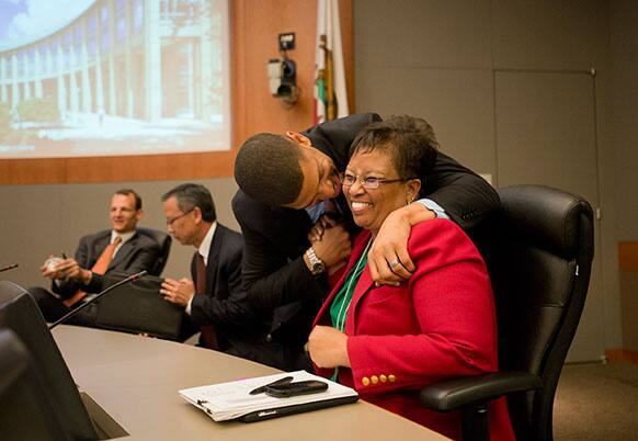 Sacramento Mayor Kevin Johnson gives council member Bonnie Pannell a kiss after her vote in support of the arena financing plan at City Hall in Sacramento, Calif.
