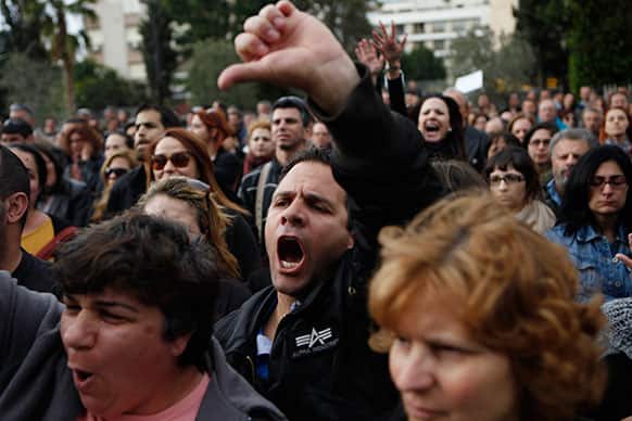 An employee of Bank of Cyprus gestures and shouts during a protest at Cyprus central bank in capital Nicosia, Cyprus.
