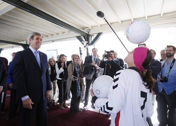 US Secretary of State John Kerry reacts as Zahra Mahmoodi, captain of Afghanistan`s women`s national soccer team, bounces an Afghan-made soccer ball off her head as Kerry meets with women-owners of the ball-making company and other Afghan women entrepreneurs at the US Embassy in Kabul.