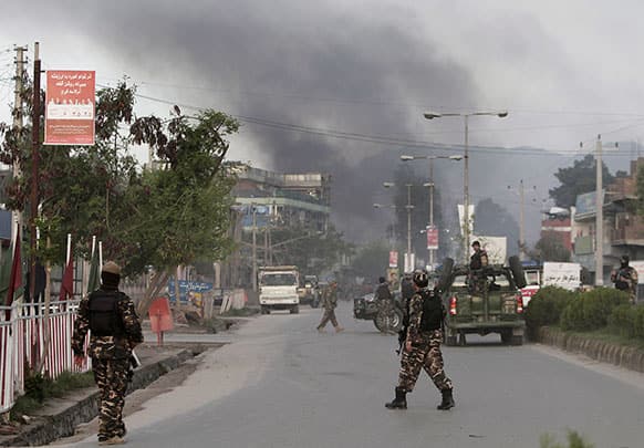 Smoke billows skyward after eight suicide bombers attacked a police headquarters in the eastern Afghan city of Jalalabad, Afghanistan, killing five police officers and wounding four others, a security official said.