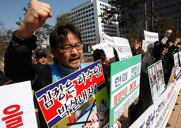 South Korean protesters shout slogans during a rally to mark the third anniversary of the sinking of South Korean naval ship
