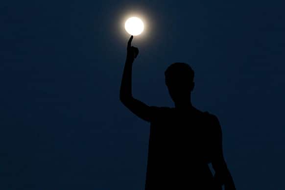 A statue atop a monument representing Cyprus` liberty, seen standing as the moon rises behind, in capital Nicosia, Cyprus.