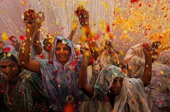 Indian widows throw flowers during Holi celebrations, or the festival of colors, at an event organized by the NGO Sulabh at the Meera Sahbhagini Ashram in Vrindavan, India.