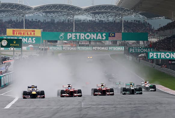 Formila One drivers, from left, Red Bull`s Sebastian Vettel of Germany, Ferrari`s Fernando Alonso of Spain, Ferrari`s Felipe Massa of Brazil and Mercedes` Lewis Hamilton of Britain race side by side during the start of the Malaysian Grand Prix at Sepang.