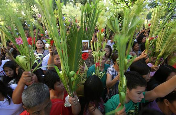 A Filipino Catholic priest blesses palm fronds outside the Santo Domingo Church in suburban Quezon city, north of Manila, Philippines during Palm Sunday rites.