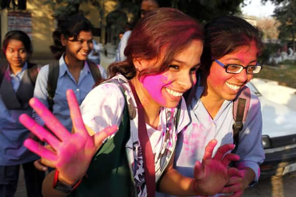 An Allahabad University student, face smeared with colored powder, gestures as she celebrates Holi, the festival of colors, in Allahabad.