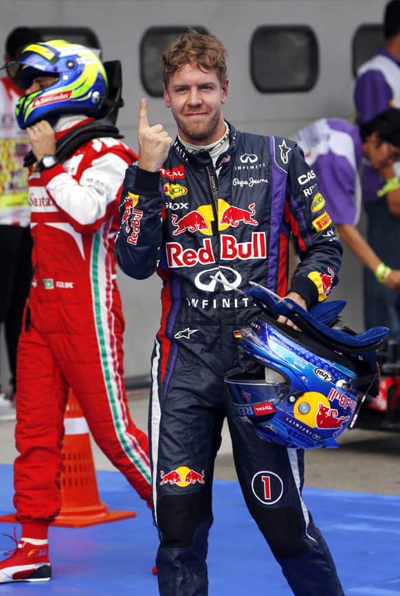 Red Bull driver Sebastian Vettel of Germany celebrates after taking the pole position after the qualifying for the Malaysian Formula One Grand Prix at Sepang, Malaysia.