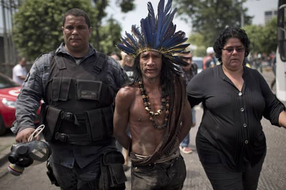 An indigenous man is arrested during clashes outside the old Indian museum, a complex that has been occupied by Indians for years, during an eviction in Rio de Janeiro.