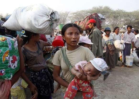 Carrying a child and belongings, Muslims refugees try to move a rescue camp in Meikhtila where ethnic unrest between Buddhists and Muslims, about 550 kilometers (340 miles) north of Yangon, Myanmar.