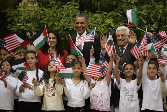 President Barack Obama, flanked by Palestinian President Mahmoud Abbas and Bethlehem Mayor Vera Baboun, are joined by children at the Church of the Nativity during their visit to the West Bank city of Bethlehem.