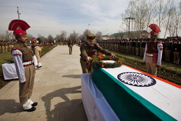 An Indian Border Security Force (BSF) officer lays a wreath on the coffin of his colleague inside their base camp on the outskirts of Srinagar.