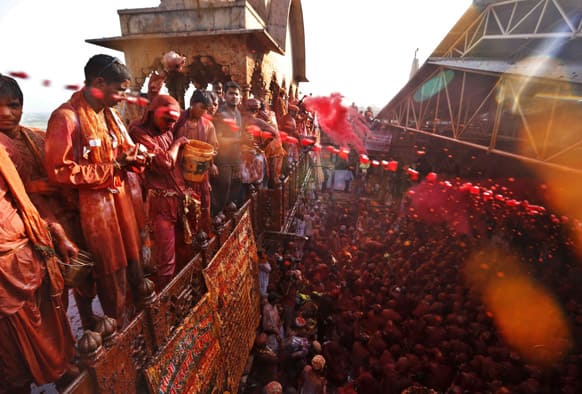 Men throw and spray colored water on men from the village of Nangaon as they sit on the floor during prayers at the Ladali or Radha temple before the procession for the Lathmar Holy festival, the legendary hometown of Radha, consort of Hindu God Krishna, in Barsana 115 kilometers from New Delhi.