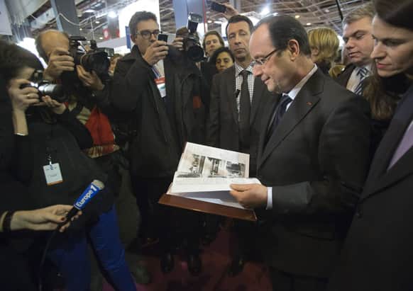French President Francois Hollande, center, and French Culture Minister Aurelie Filippetti, right, are seen during the opening of the Book Fair in Paris.