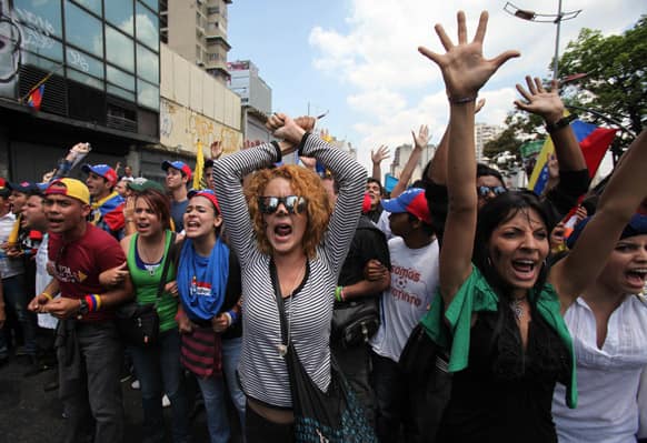 Opposition students shouts slogans against supporters of Venezuela`s late President Hugo Chavez as they are blocked by police from reaching the electoral commission, to keep them and Chavez supporters separated, in Caracas, Venezuela.