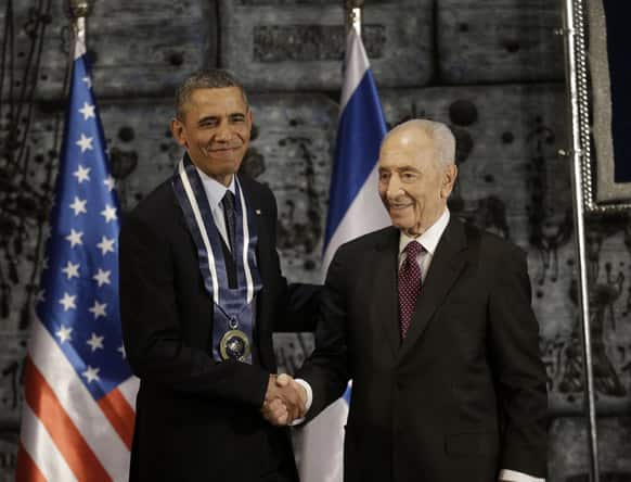 President Barack Obama shakes hands with Israeli President Shimon Peres after Peres presented him the Israeli Medal of Distinction, at a State Dinner at President’s residence in Jerusalem, Israel.
