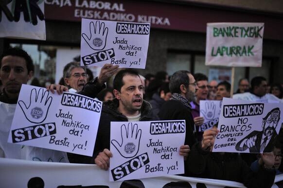 Placards depicting Spanish Prime Minister Mariano Rajoy are carried by people to protest against evictions in front a saving bank in Baranain, near to Pamplona northern Spain.