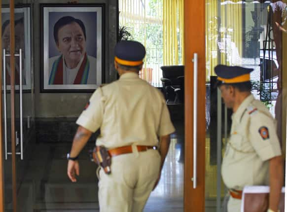 A photograph of father and late actor Sunil Dutt hangs in the background as police officers enter the residence of Sanjay Dutt in Mumbai.