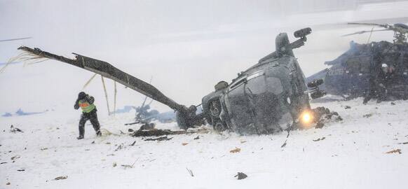 Rescue workers examine two crashed helicopters of the German federal police on a field at the Olympic Stadium in Berlin, Germany. The two helicopters collided as they approached for landing during an exercise of the federal police.